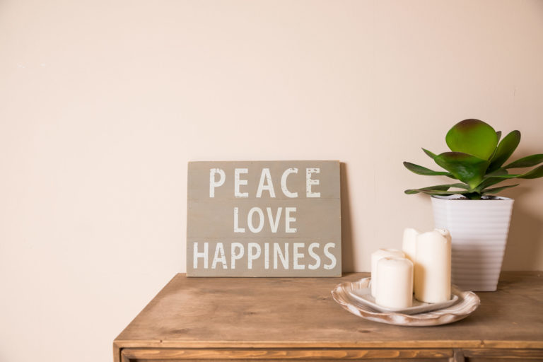 bougies posées sur une commode avec un cadre peace love happiness
