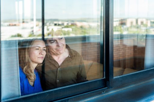 Un couple regarde l'horizon derrière une fenêtre