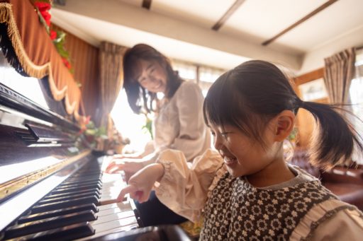 Une mère apprend à sa fille à jouer du piano