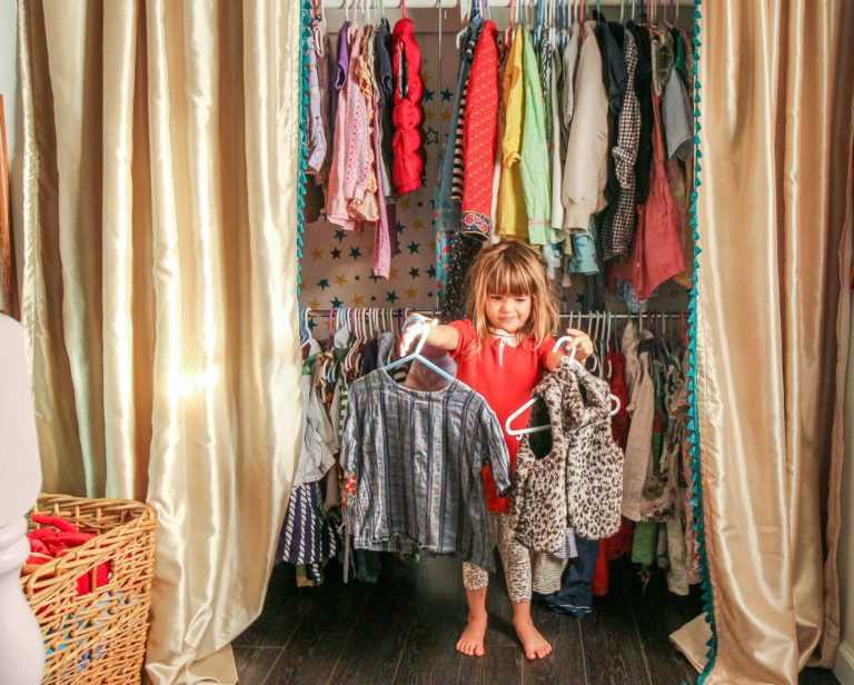 Une jeune fille choisit ses vêtements dans le dressing