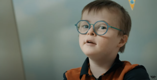 Un enfant porteur de trisomie avec des lunettes bleues