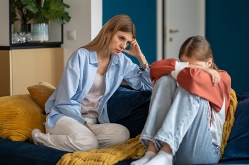 Une maman déçue de sa fille adolescente qui boude sur le canapé